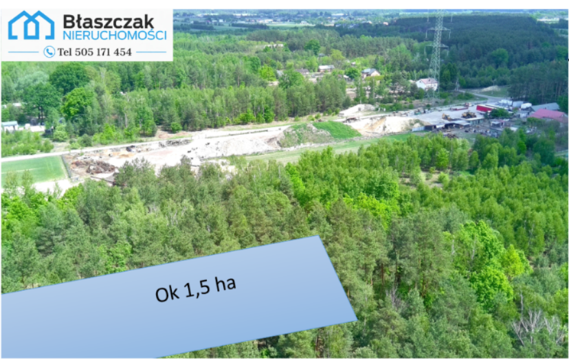 Ujęcie z lotu ptaka przedstawiające rozległy teren o powierzchni około 1,5 ha, położony w otoczeniu lasów i infrastruktury drogowej, z widoczną zabudową oraz terenami przemysłowo-usługowymi w pobliżu.